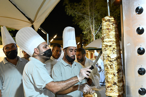 Chefs preparing shawarma in professional kitchen