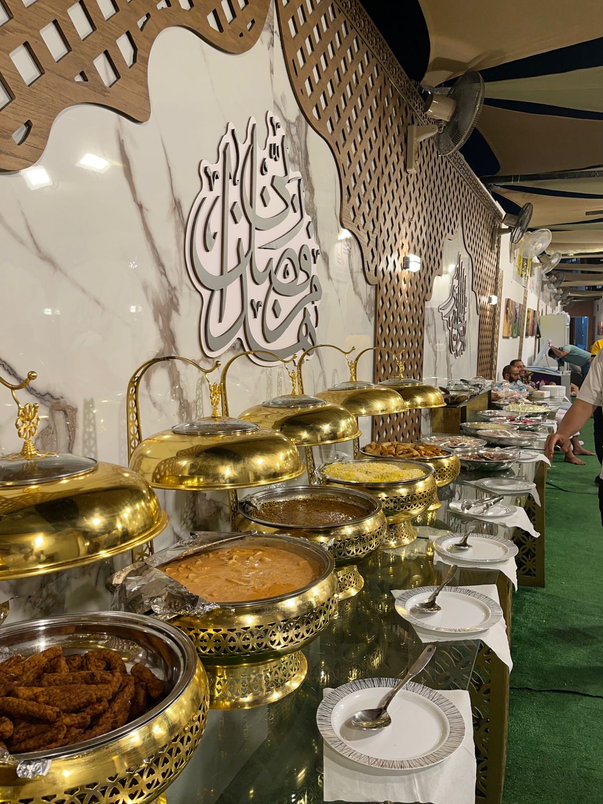Luxurious buffet with golden serving dishes and Arabic calligraphy