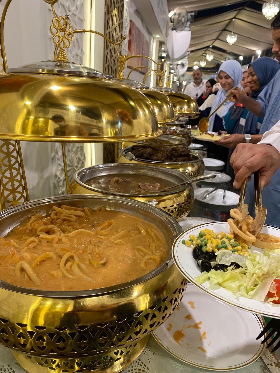 Elegant buffet setup with golden serving dishes and traditional Arabic food