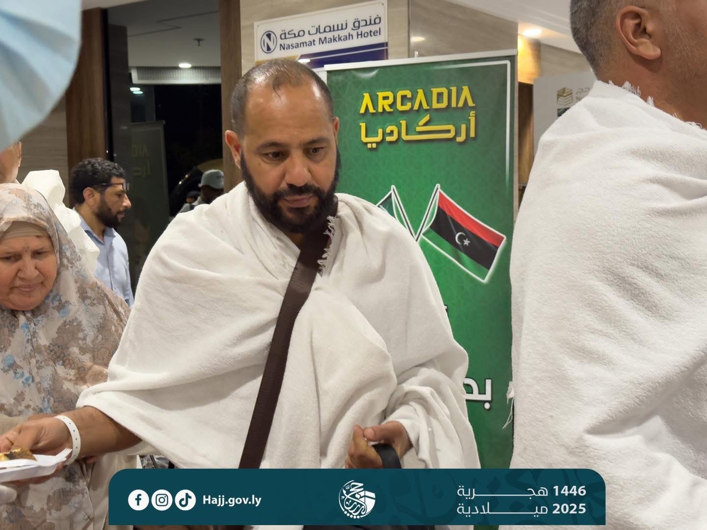 Person in ihram at Hajj with Arcadia banner